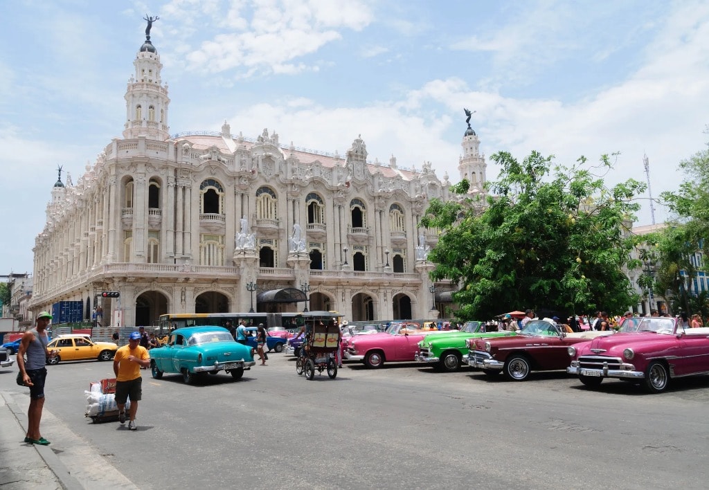 Gran Teatro de La Habana with rainbow of colorful vintage cars and street life Cuba