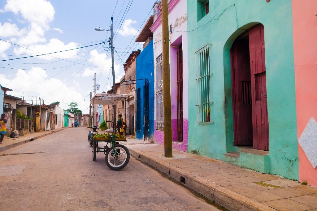 Colorful colonial street with cart vendor, Cuba
