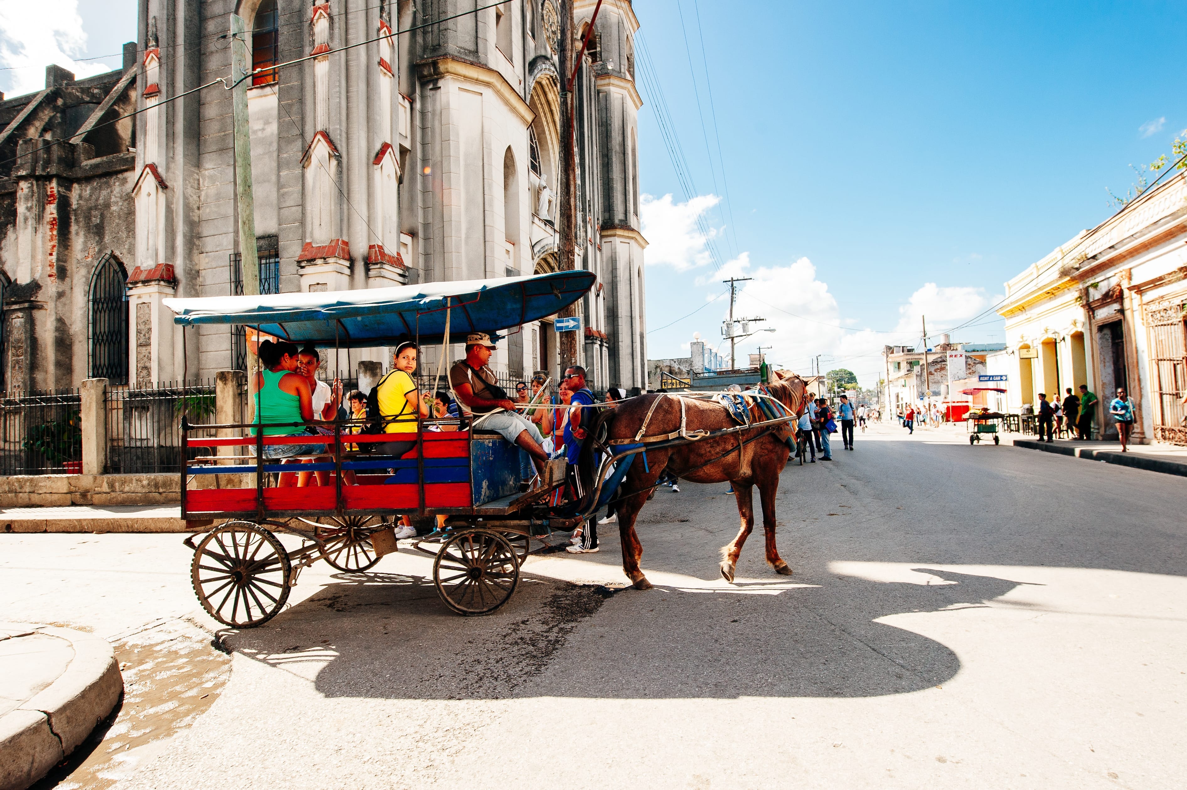 Colorful horse-drawn carriage passing Gothic cathedral corner in Santa Clara Cuba