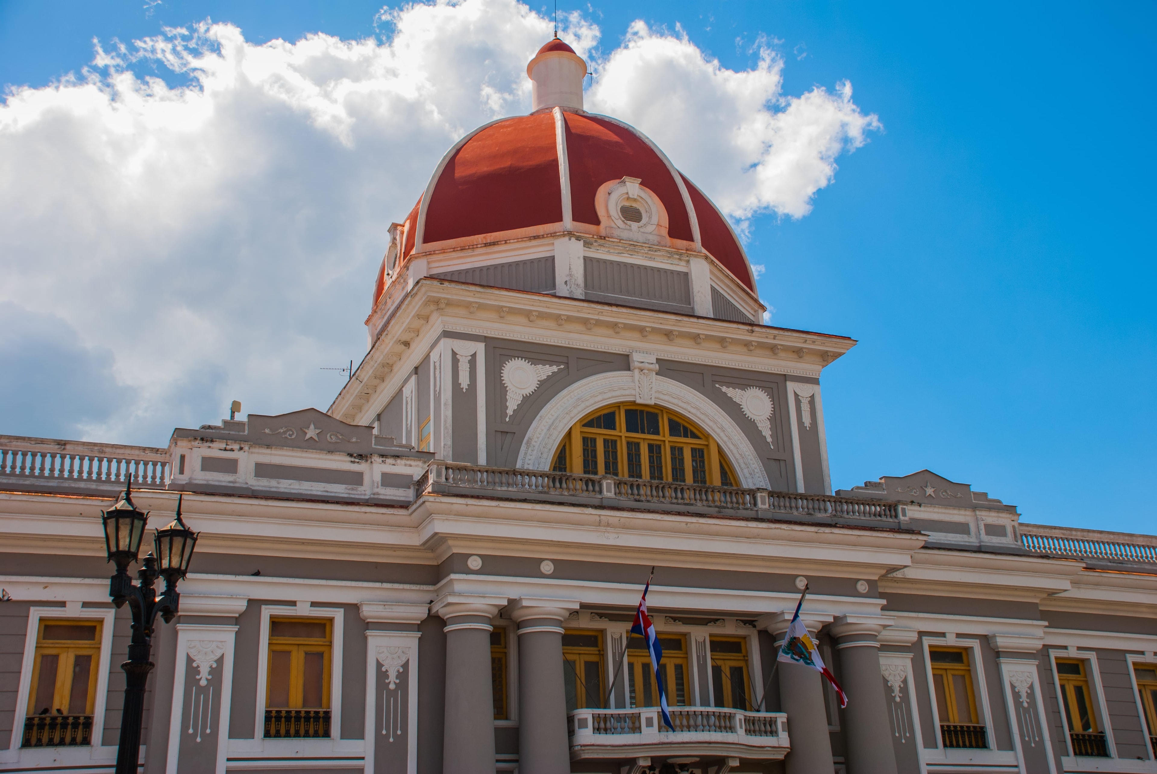 Cienfuegos City Hall neoclassical facade with large red dome and Cuban flag, Cuba